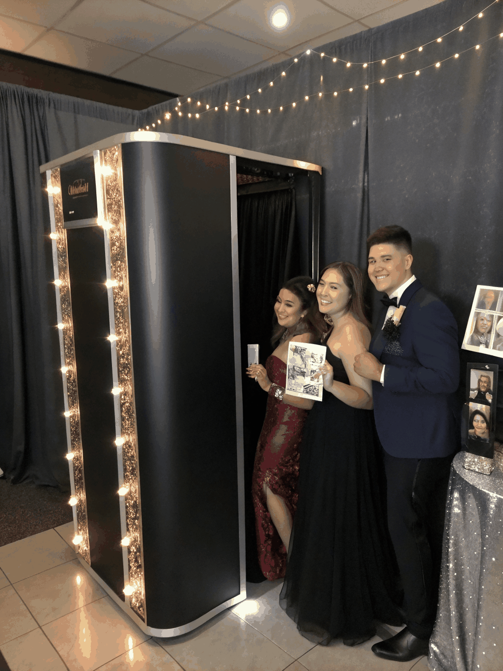 Open-air photo booth setup with deep velvet backdrop and studio strobe lighting
