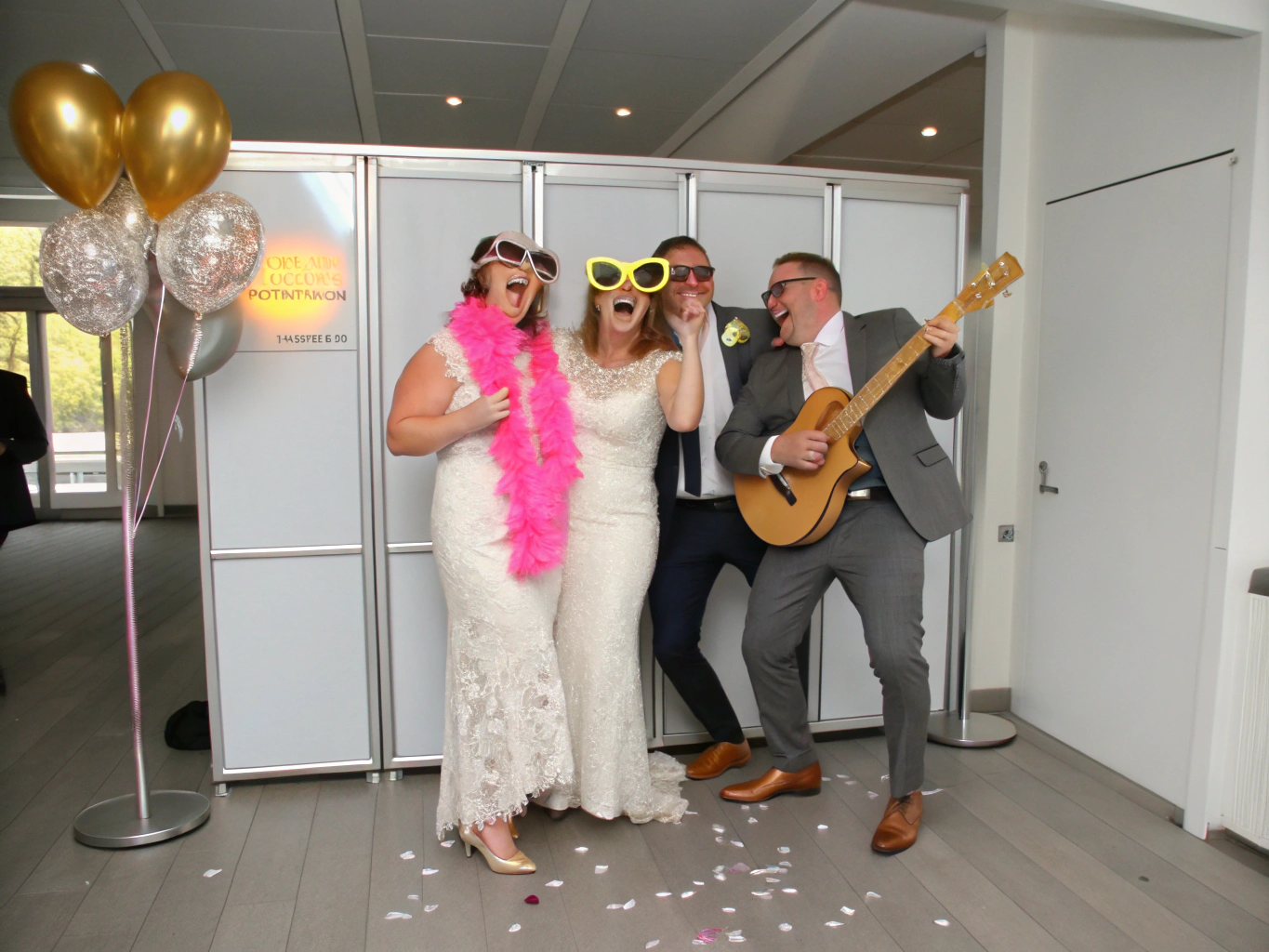 Wedding guests laughing together inside a modern open-air photobooth